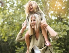 Little,Girl,Sitting,On,Her,Mother's,Shoulders.