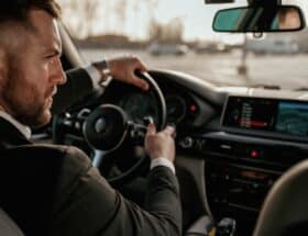 Wealthy man driving a nice car.